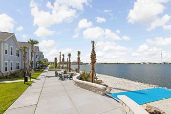 A view of a walkway with a pool and palm trees.